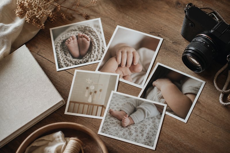 Family baby photo story prints arranged with a camera and linen album in warm natural light